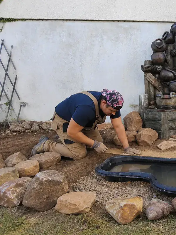 Axel Reynes, paysagiste artisan à Fontainebleau, en train d'installer un bassin